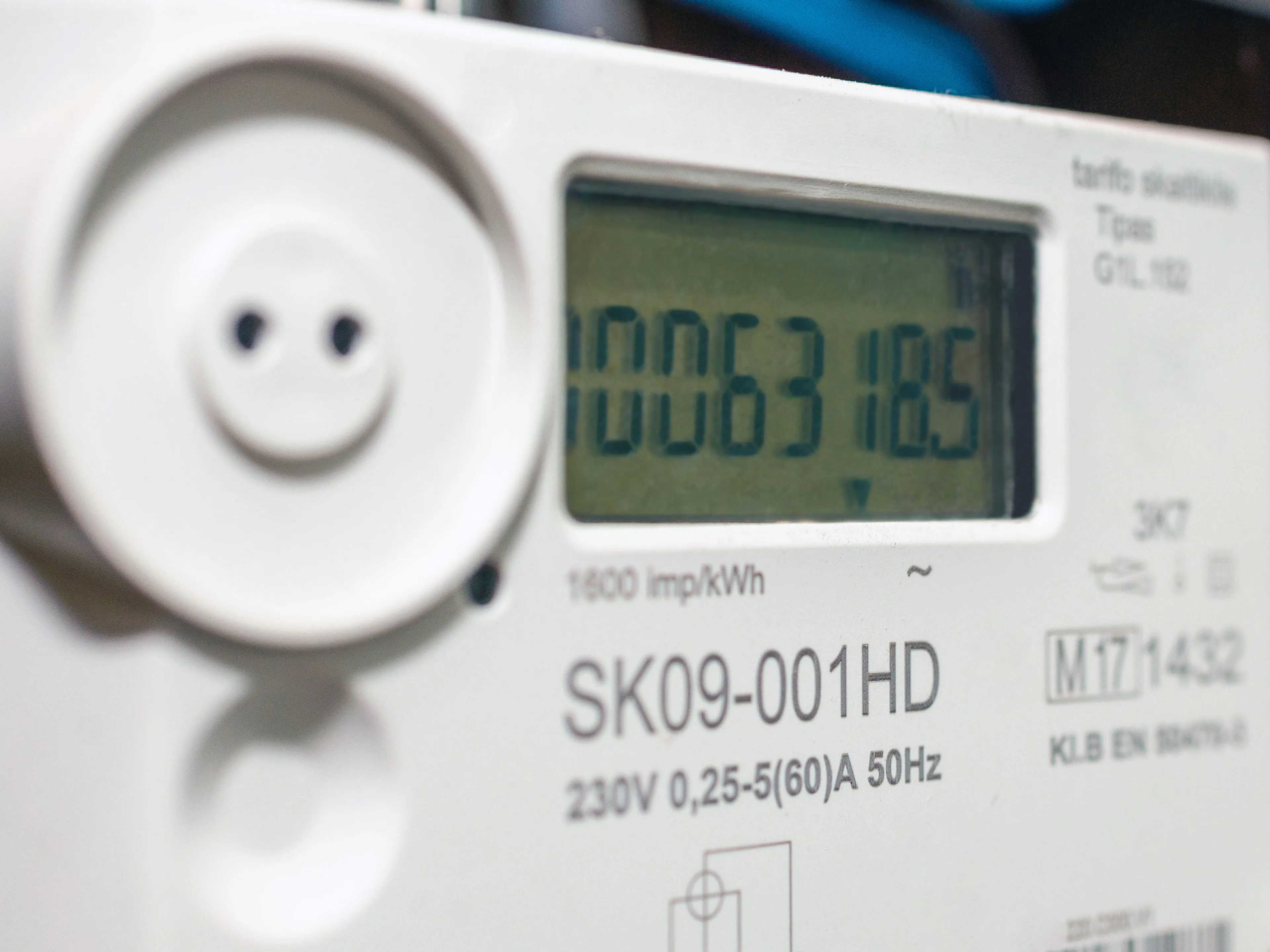 Nahaufnahme eines digitalen Stromzählers mit der Anzeige "006318.5" und verschiedenen technischen Daten, die auf dem Gerät sichtbar sind.