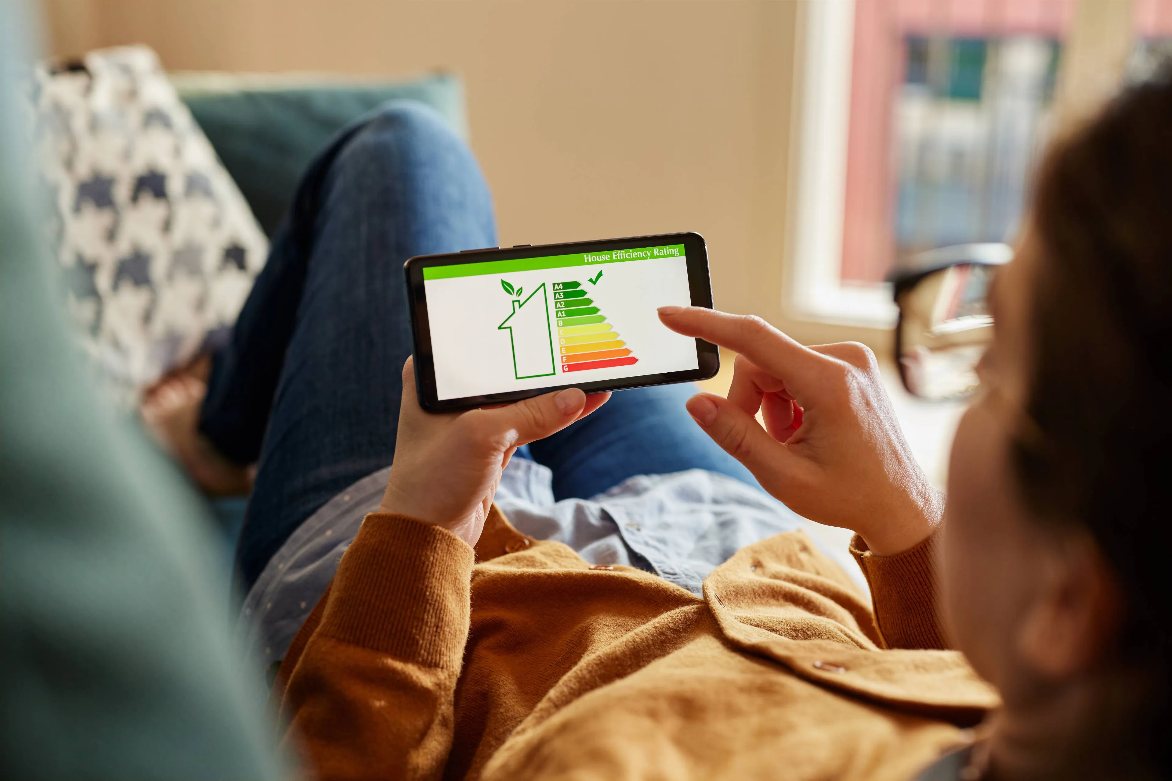 Frau prüft Energieeffizienz-Rating auf dem Smartphone – smarter Überblick mit Mark-E.